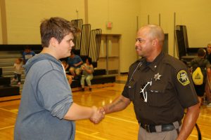 Sean Barnett, ninth grade, Zemmer Middle School, shakes the hand of Lapeer County Sheriff’s Dept. Deputy Jimmy White during Thursday’s open house at the school. Barnett says it “feels good” to know Deputy White is there. Photo by Andrew Dietderich