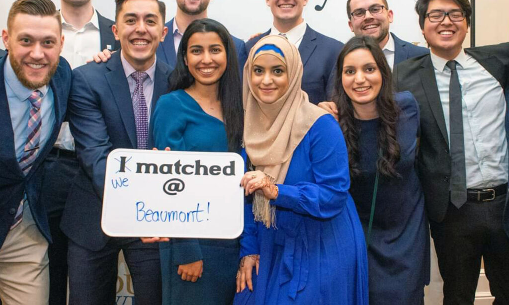 Jamilah Alhashidi, M.D. (right of sign) celebrates Match Day in 2019 with her OUWB classmates.